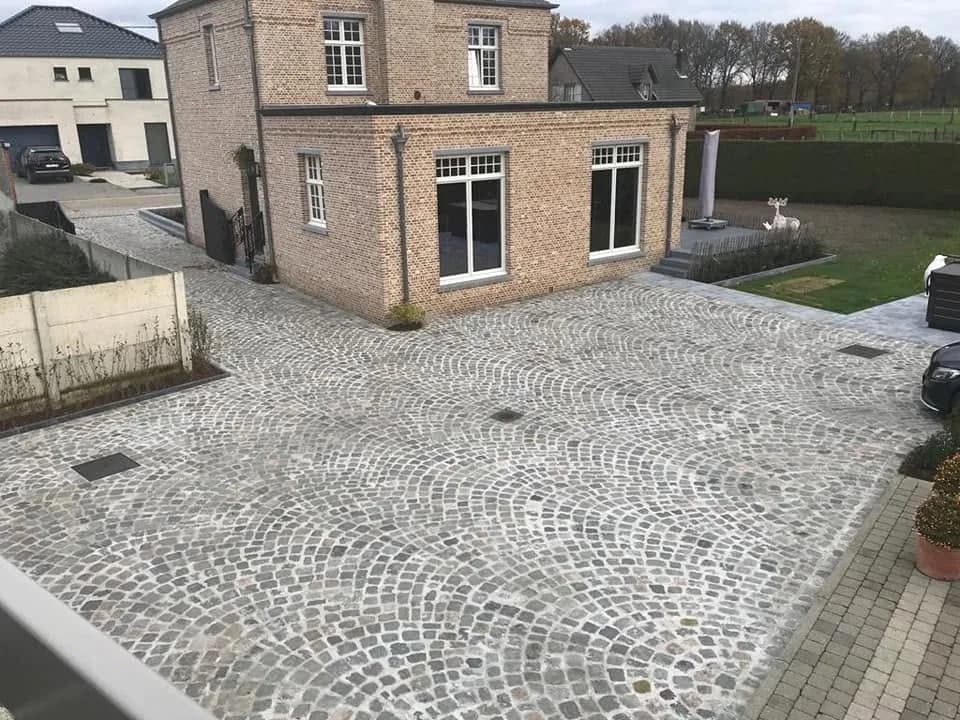 Overzicht van een ruime oprit in kasseien in waaierverband