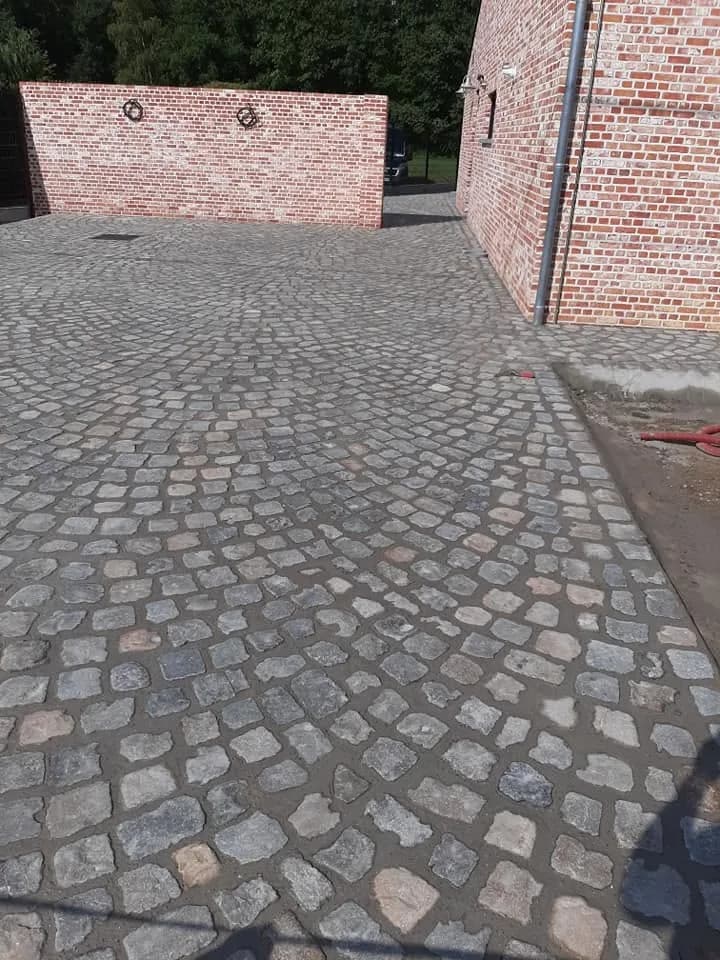 Oprit in kasseien tussen bakstenen gebouwen