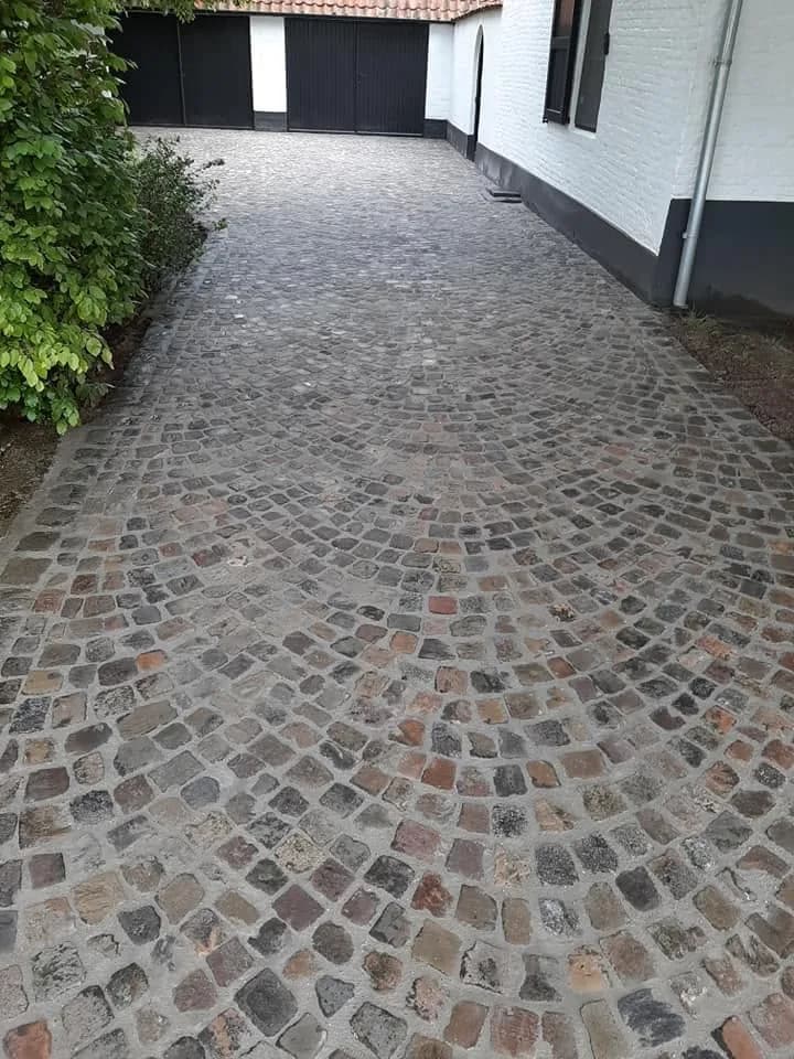 Oprit in boerenkasseien naar een garagepoort